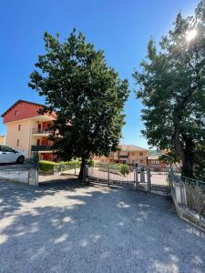 drzewo i płot przed budynkiem w obiekcie Casavacanze Valleverde a Mosciano Sant'Angelo w mieście Mosciano SantʼAngelo