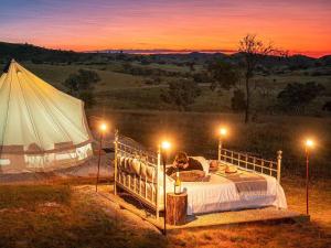 a woman laying on a bed in front of a tent at Glenayr Farm in Windeyer +61 photos