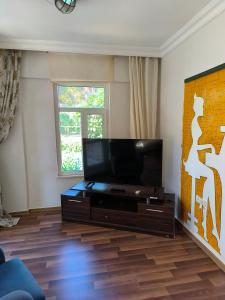 uma sala de estar com uma televisão de ecrã plano em Villa Green Garden Alanya 5B em Alanya