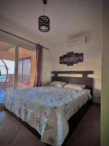 a bedroom with a bed and a large window at Telal Al Sukhna Only families in Ain Sokhna