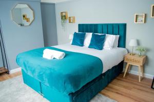 um quarto azul com uma cama grande e lençóis azuis em Luxury Cityscape London - Free Parking! em Ealing