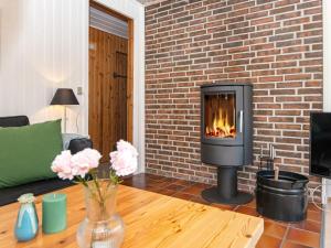 a living room with a fireplace in a brick wall at 7 person holiday home in Grenaa in Grenå