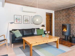 a living room with a couch and a fireplace at 7 person holiday home in Grenaa in Grenå