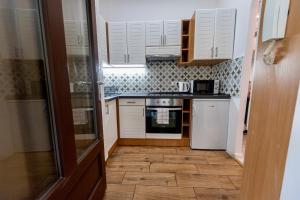 een kleine keuken met witte kasten en een tegelvloer bij Ráday Boutique Apartment in Boedapest