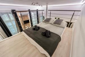 een slaapkamer met een groot bed met 2 zwarte schoenen bij Ráday Boutique Apartment in Boedapest
