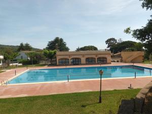 una gran piscina con un edificio en el fondo en Apartamento loft, jardín y piscina privada, en Romanyà de la Selva