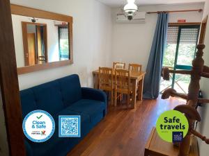 a living room with a blue couch and a table at Gerês River - Apartamento na Natureza in Geres