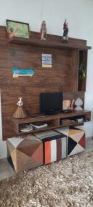 a living room with a table with a television at A KAsinha do Murubira in Mosqueiro