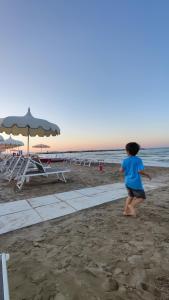 a young girl running on the beach at SeaSide BnB -Elegante Appartamento- FRONTE MARE in Porto San Giorgio