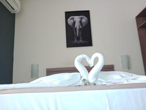 two swans in a bed with a picture of an elephant at Sallimas Hotel in Sorocaba