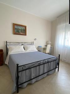 1 dormitorio con 1 cama grande con sábanas blancas en B&B Casa Benvenuto, en Diamante