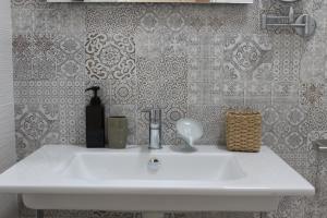 a white sink in a bathroom with wallpaper at B&B Casa Benvenuto in Diamante +70 photos