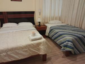 duas camas sentadas uma ao lado da outra num quarto em HOTEL CASTILLO MAGICO (EX CHAVIN SEÑORIAL? em Barranca