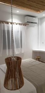 a bedroom with a bed and a hanging light at Ilias Place in Ios Chora