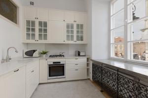 eine weiße Küche mit weißen Schränken und einem Fenster in der Unterkunft Family Apartment Freta Warsaw Old Town by Renters in Warschau