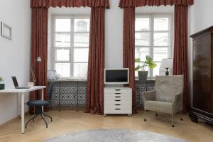 ein Wohnzimmer mit einem TV und einem Schreibtisch mit einem Stuhl in der Unterkunft Family Apartment Freta Warsaw Old Town by Renters in Warschau