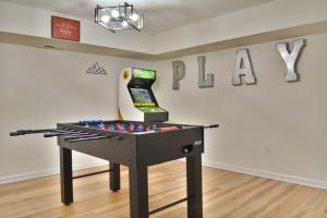 a ping pong table in front of a wall with the word play at In The Woods - 5 BR Chalet with Game Room, Fire Table and Hot Tub in McGaheysville