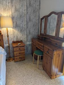 ein Schlafzimmer mit einem Holzschreibtisch mit einem Spiegel und einem Stuhl in der Unterkunft Fly Dodo Summer Residence in Marsaskala