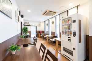 um restaurante vazio com mesas e um frigorífico em Travel Inn Kofu em Kofu
