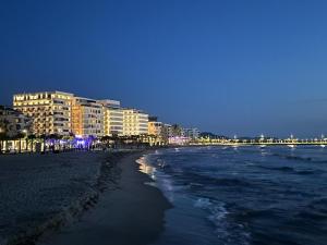 una playa con edificios y el océano por la noche en Ermar Apartment 2 en Golem