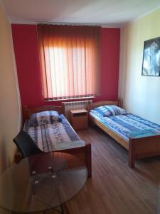 een kamer met 2 bedden, een stoel en een raam bij Zajazd Morfeusz in Rękusy
