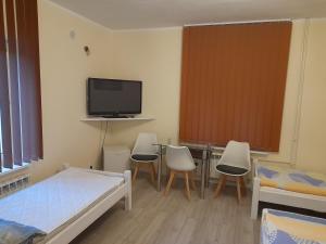 1 dormitorio con 1 cama, mesa y sillas en Zajazd Morfeusz, en Rękusy