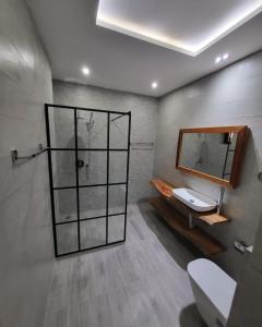 a bathroom with a toilet and a sink and a mirror at Giani Lodge in Lomé