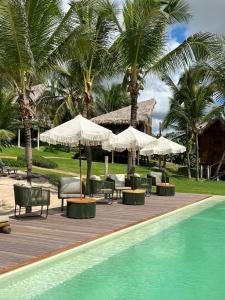 a resort with chairs and umbrellas and a swimming pool at Villa Mango in Icaraí