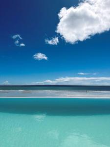 un cuerpo de agua con un cielo azul y nubes en Villa Mango en Icaraí