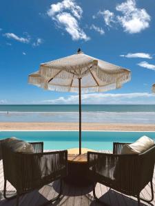 una mesa y sillas bajo una sombrilla en la playa en Villa Mango, en Icaraí