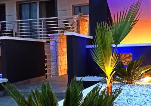 um resort com uma palmeira em frente a um edifício em Kemilia Matera em Matera