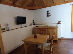 a dining room with a table and a tv on the wall at La Casita de la Vega in Icod de los Vinos