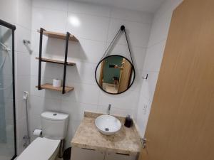 a bathroom with a toilet and a sink and a mirror at Flat Buenos Ayres Cabo Branco in João Pessoa +27 photos