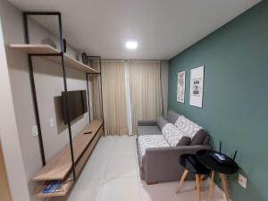 a living room with a couch and a tv at Flat Buenos Ayres Cabo Branco in João Pessoa