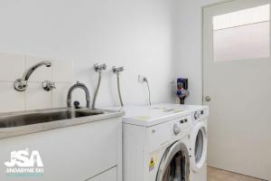 eine Küche mit einer Waschmaschine und einem Waschbecken in der Unterkunft Berridale Bliss in Berridale