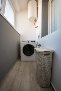 una lavanderia con lavatrice e finestra di Captain’s Apartment a Zara (Zadar)