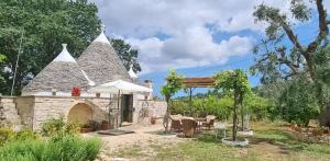 uma casa com um telhado com uma mesa e um guarda-chuva em Trullo Farfalle em Ceglie Messapica