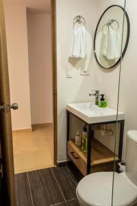La salle de bains est pourvue d'un lavabo et d'un miroir. dans l'établissement Praia Apartaestudios Sabaneta, à Sabaneta