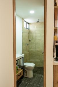 a bathroom with a toilet and a sink and a shower at Praia Apartaestudios Sabaneta in Sabaneta