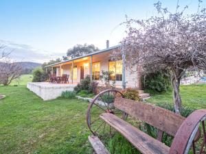 a wooden bench in front of a house at Halls on Falls Homestead in Strath Creek