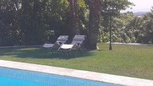 een groep stoelen naast een zwembad bij Quarto Amélia in Fogueira