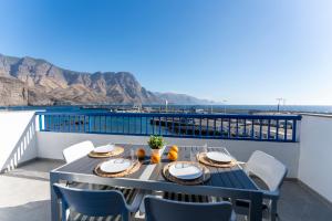 - une table sur un balcon avec vue sur l'océan dans l'établissement Agaete White&Blue House, à Agaete