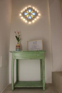 un tavolo verde con un vaso di fiori di Mediterre Domus a Casamassima