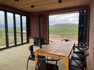 einen Tisch und Stühle auf einer abgeschirmten Veranda mit Aussicht in der Unterkunft Luxury villa - in Golden Circle - Freyjustíg 13 Selfoss in Búrfell