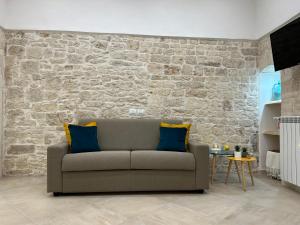 ein Wohnzimmer mit Sofa und Ziegelwand in der Unterkunft Mediterre Domus in Casamassima