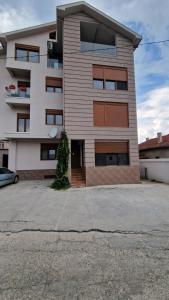 a building with a parking lot in front of it at Ilija Apartments in Gevgelija
