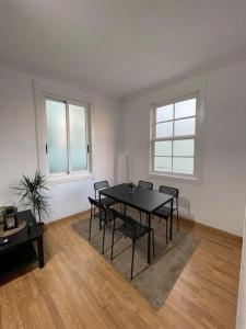 een eetkamer met een zwarte tafel en stoelen bij Atico Vintage con Terraza in Vigo