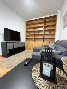 ein Wohnzimmer mit einem Sofa und einem TV in der Unterkunft Atico Vintage con Terraza in Vigo