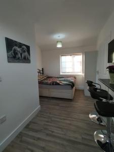 a room with a bed and a table and chairs at Stylish studio flat with Parking in Enfield