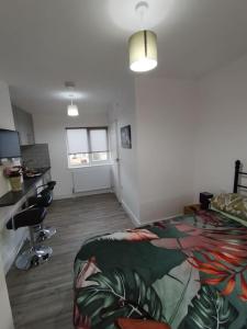 a room with a bedroom with a bed and a desk at Stylish studio flat with Parking in Enfield